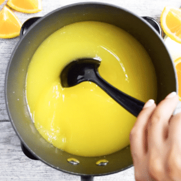 Mixing yellowish orange solution in nonstick pot. 